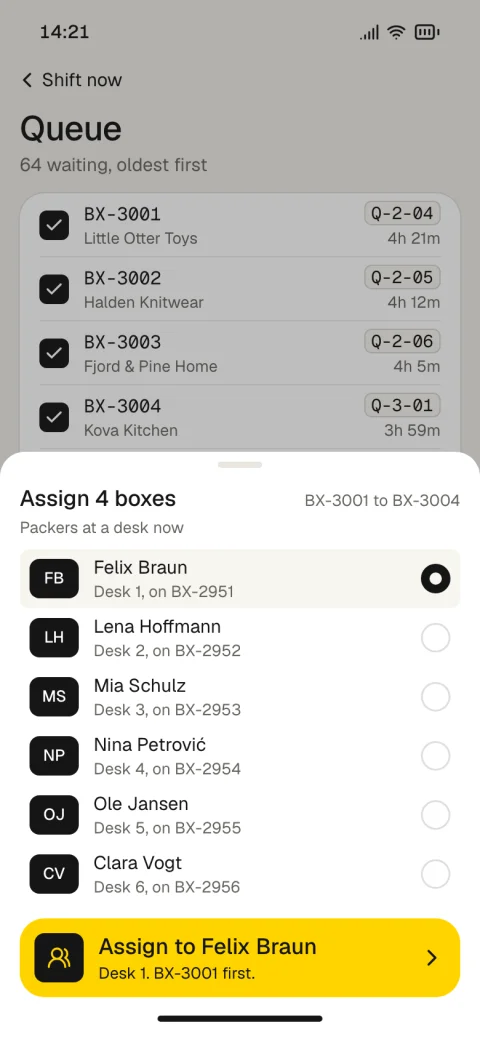 Assigning four queued boxes to a packer at a desk.